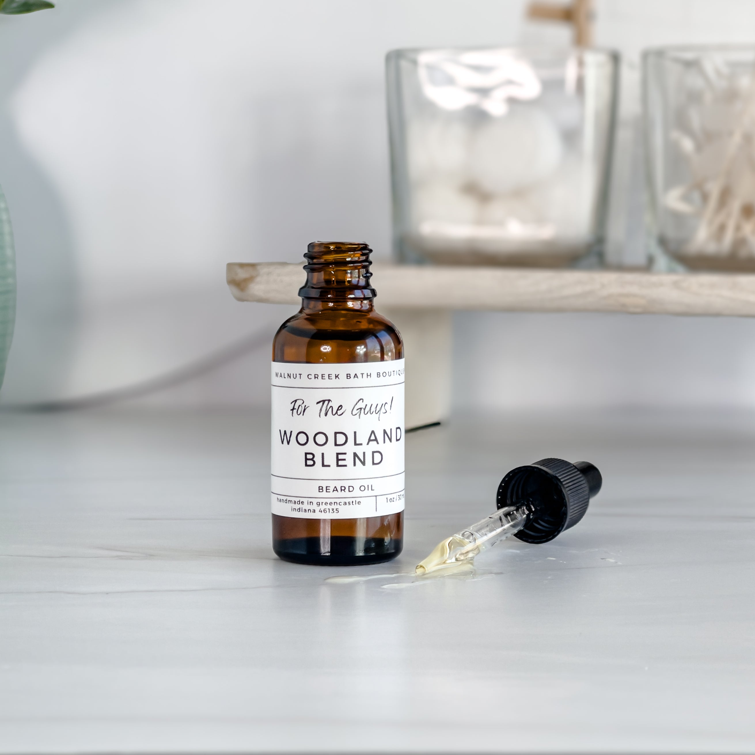 our beard oil is a lovely amber color as shown here with the dropper out of the bottle with some oil spilling out on counter