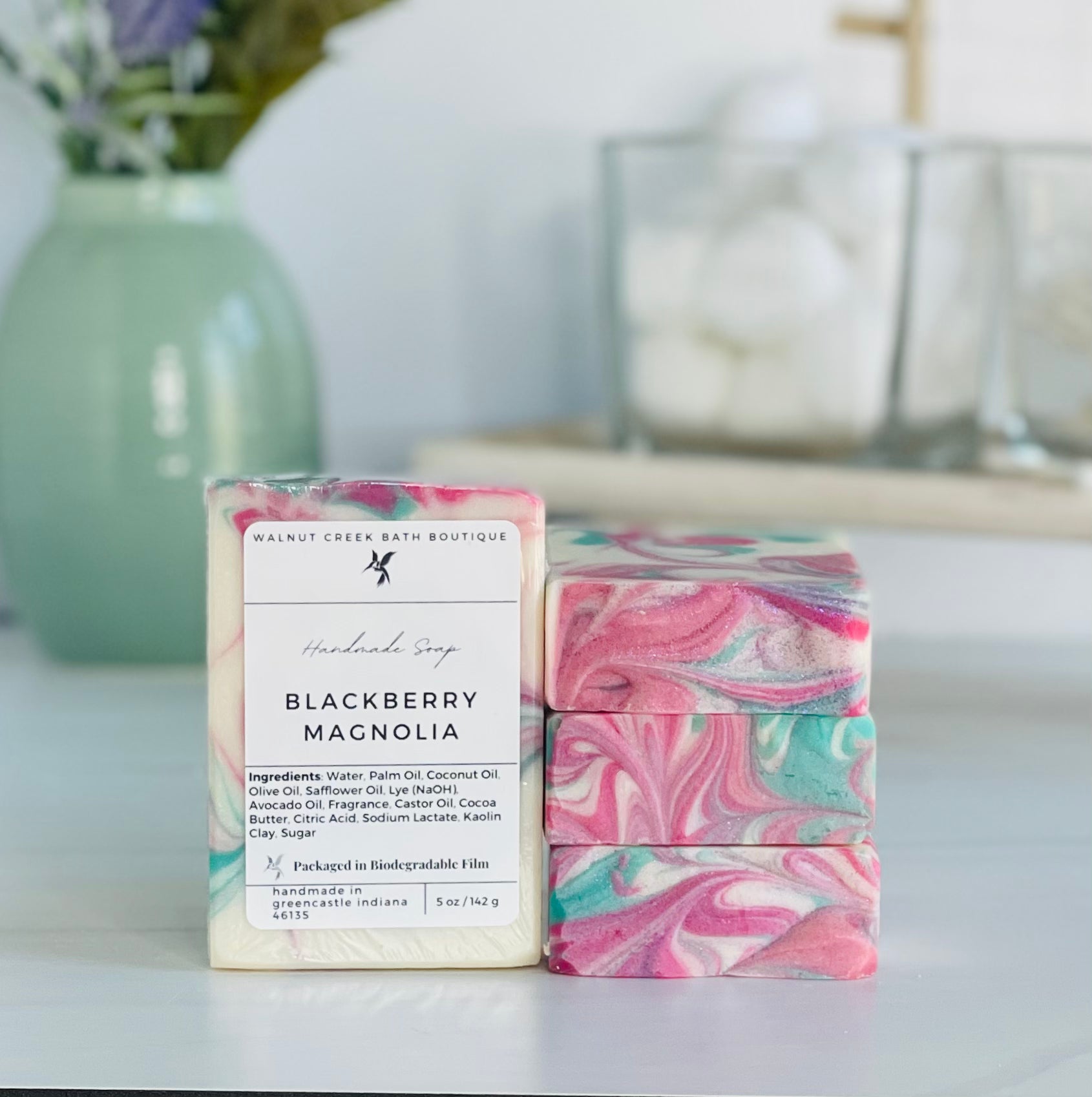 a blackberry magnolia soap is standing tall packaged in it&