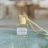 citrus sunshine car diffuser shown up close on a green cloth in front of a wicker basket.