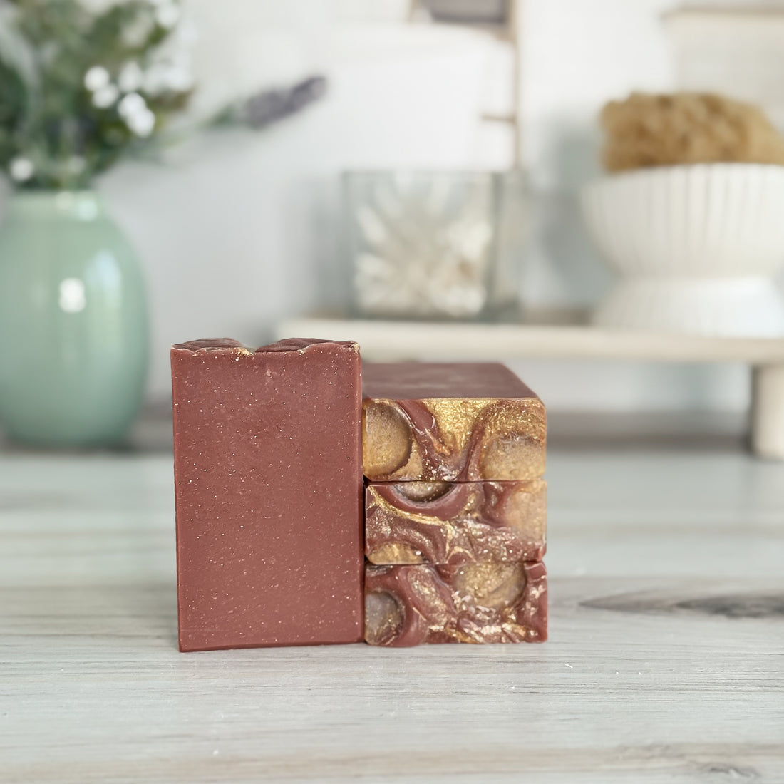 Two soap bars with different textures and colors on a wooden surface.