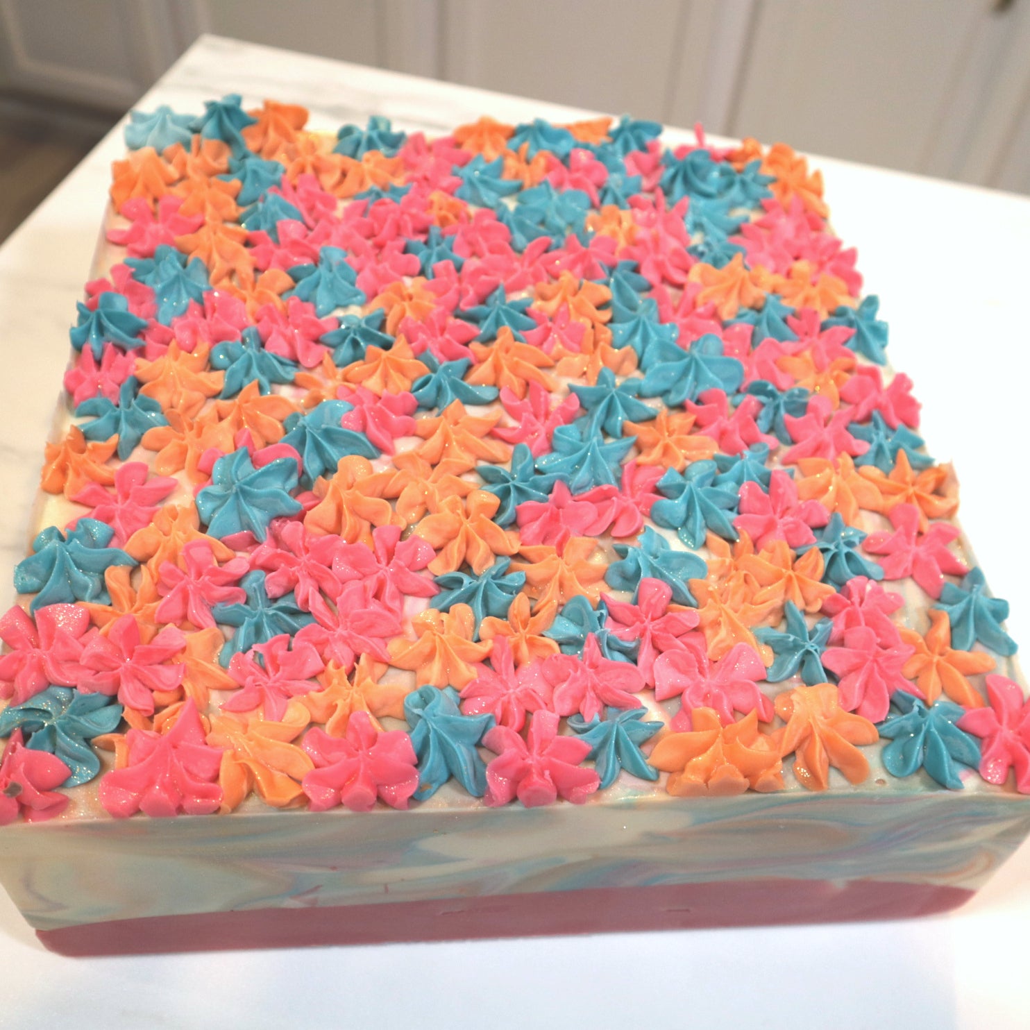 a full slab of day dreams soap showing the pink, orange and blue dollops of soap piping!