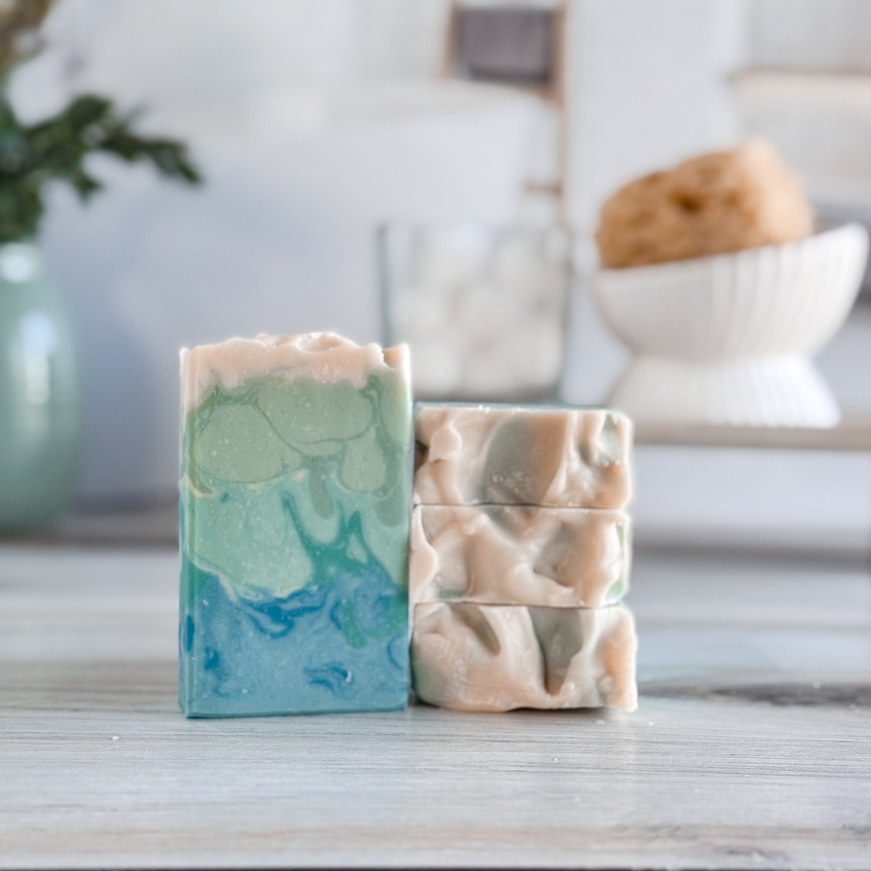 Two soap bars with marbled patterns on a wooden surface.