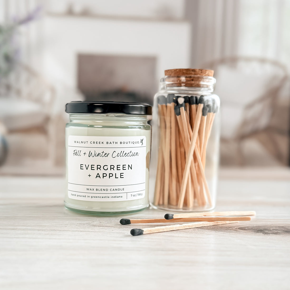 evergreen and apple candle with matchsticks laying about
