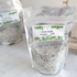 a large bag of foot soak is shown with botanicals on the label and a window to show all the salts and botanicals in the bag. there is another bag sort of in the background to the left.