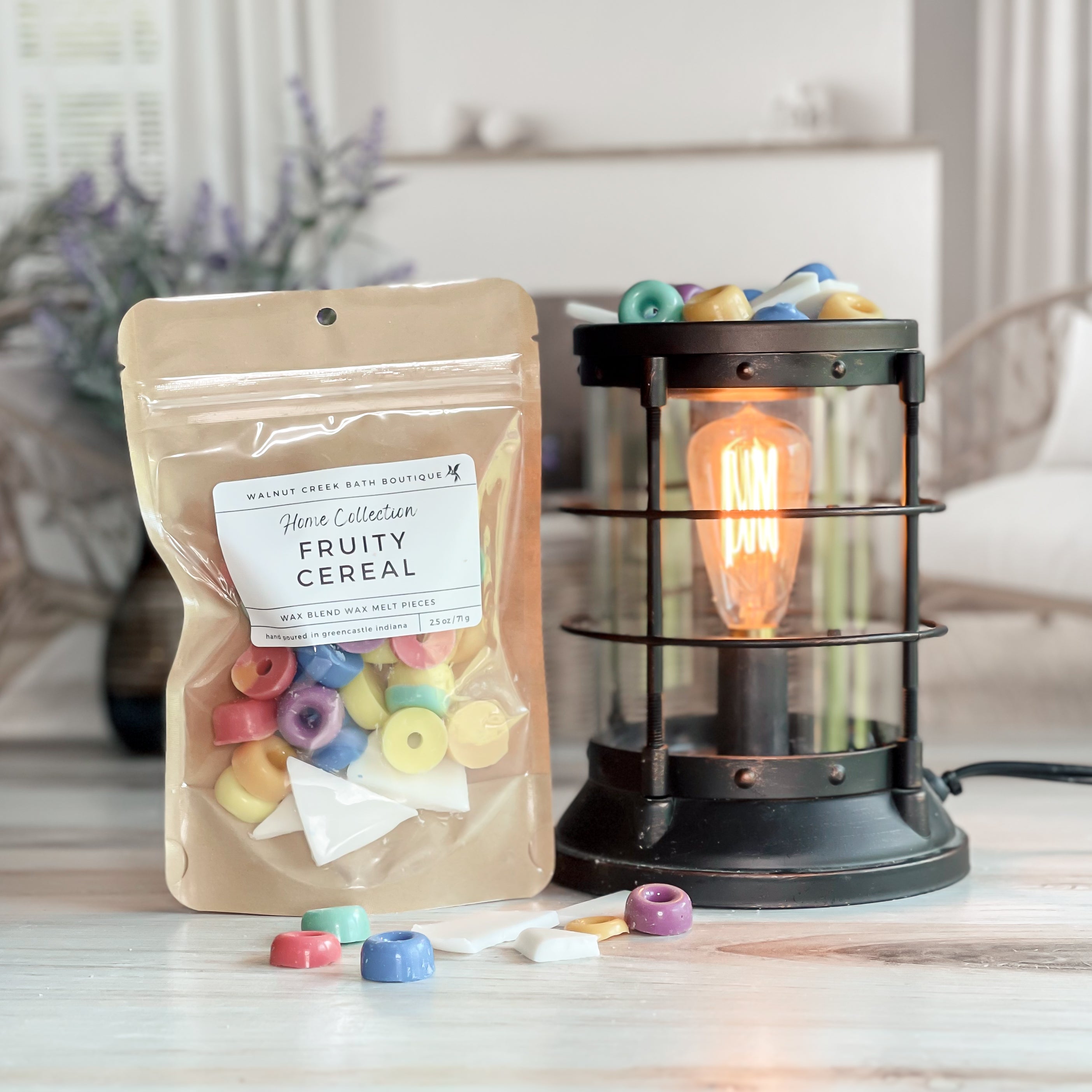 fruity cereal wax melt bag next to lit burner. there are wax melts on the table scattered about to shoe the pieces - these are cute cereal pieces in all the colors along with white "milk" looking wax brittles