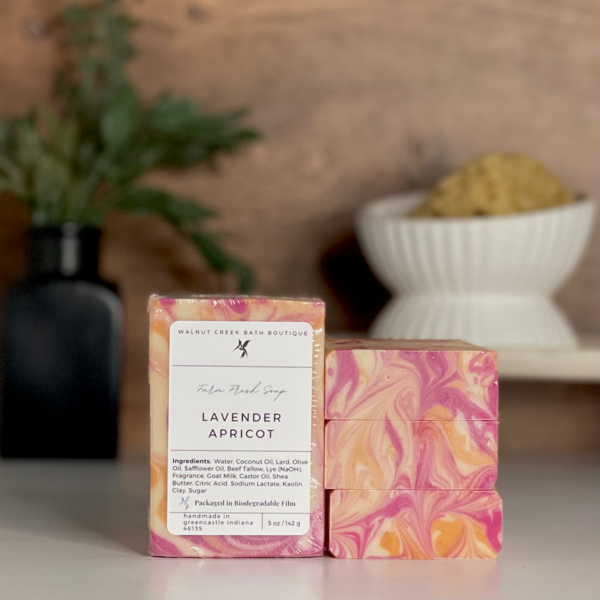a lavender apricot soap is standing tall packaged in it&