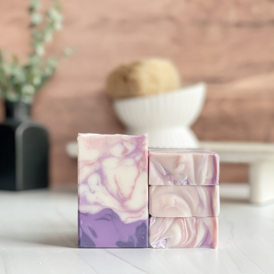 Marbled pink and purple soap bars on a white surface with a blurred background