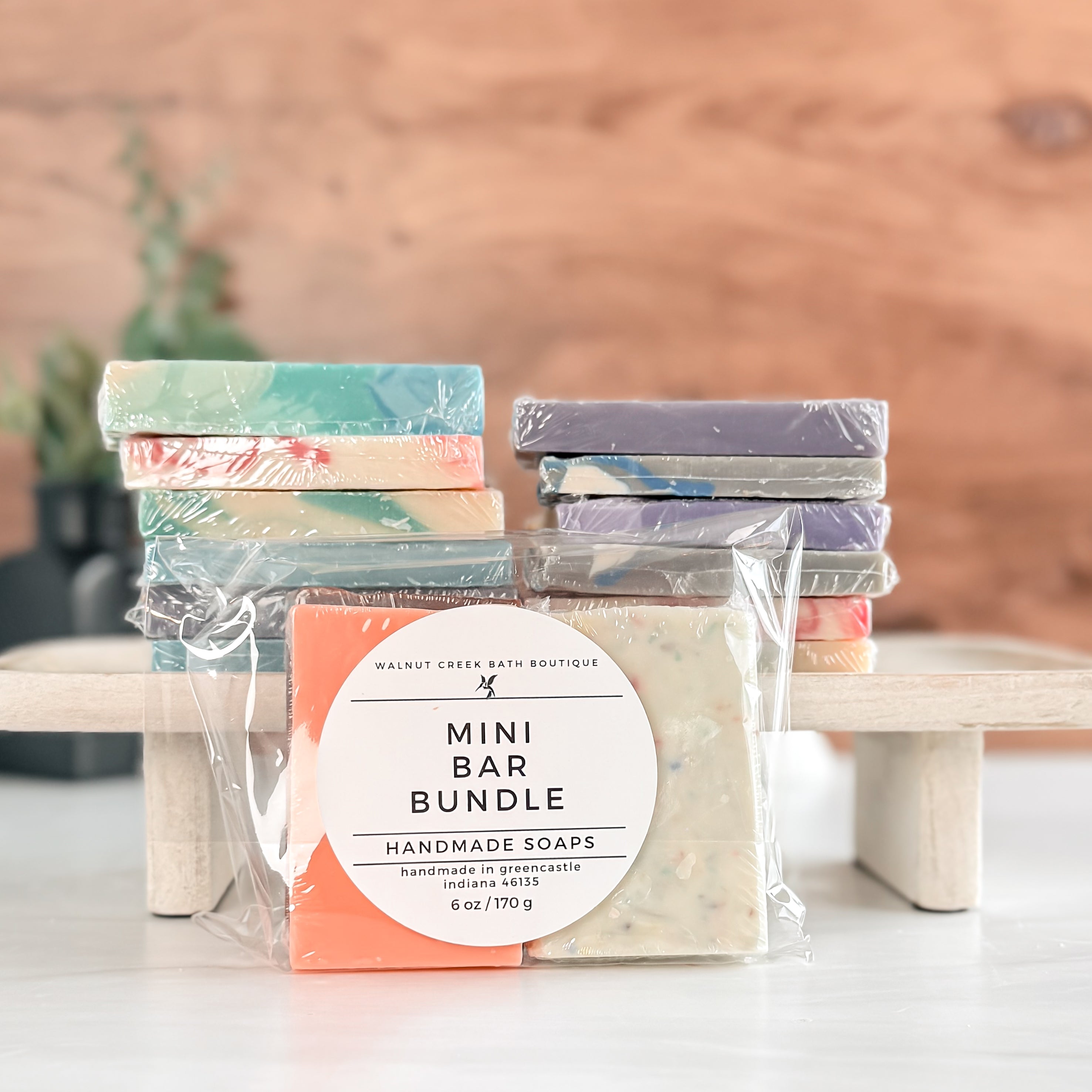Packaged mini bar bundle of handmade soaps with a wooden background
