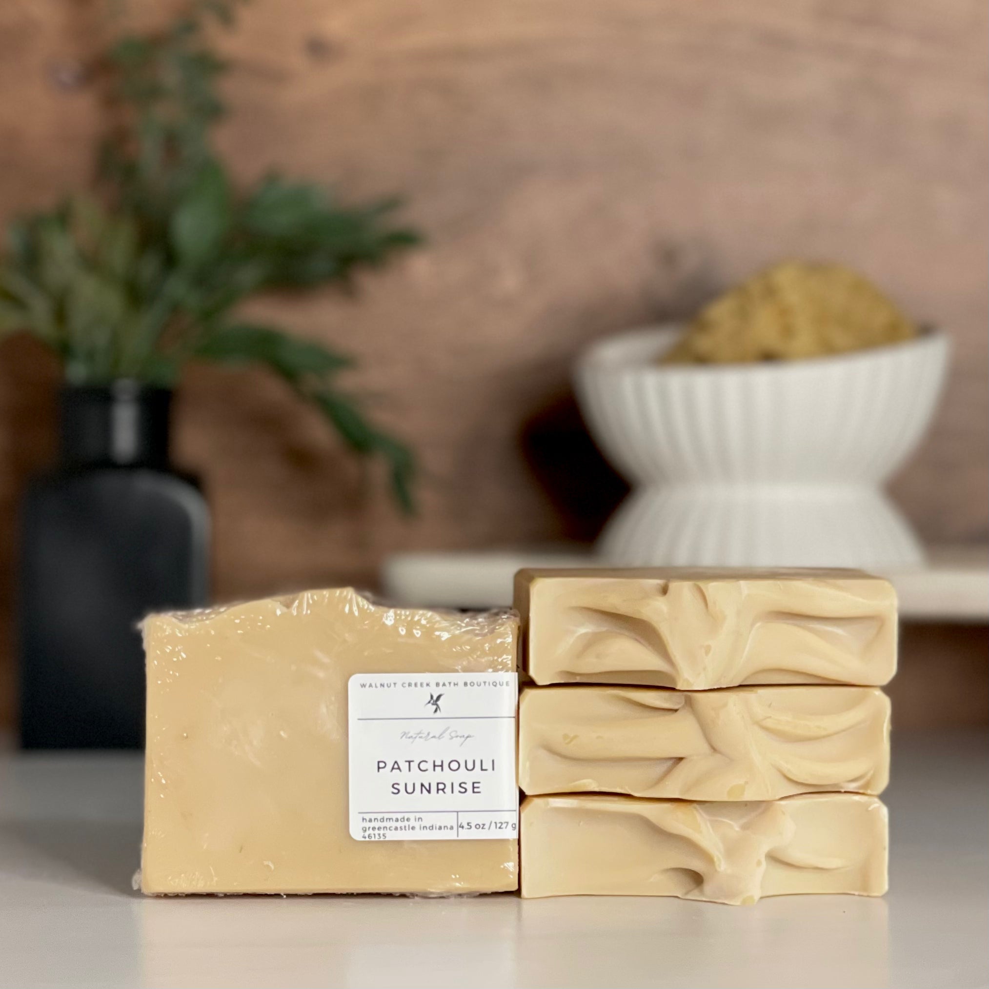 a patchouli sunrise soap is standing tall packaged in it&