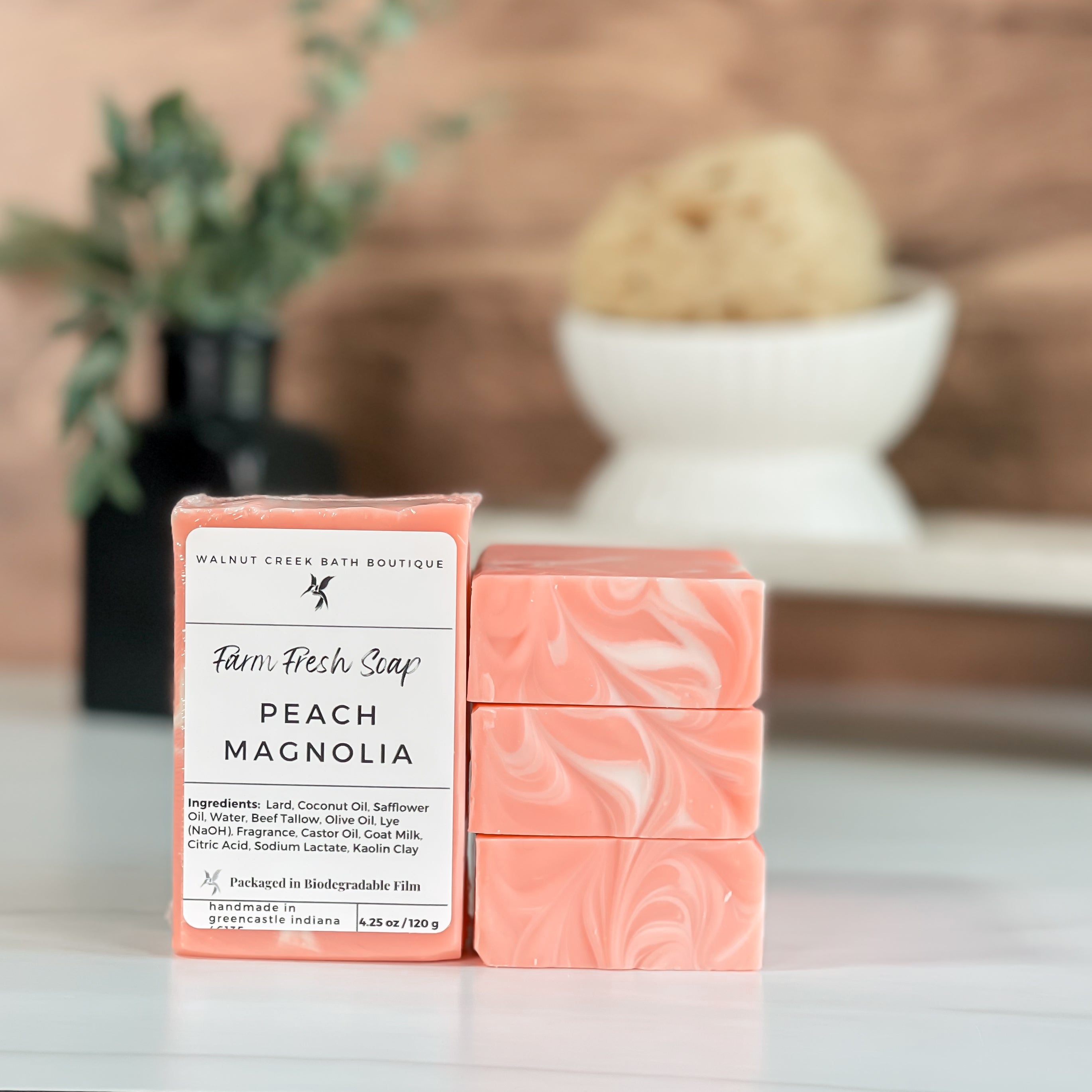 peach magnolia soaps stacked to show the pretty peach color with white swirls on tops