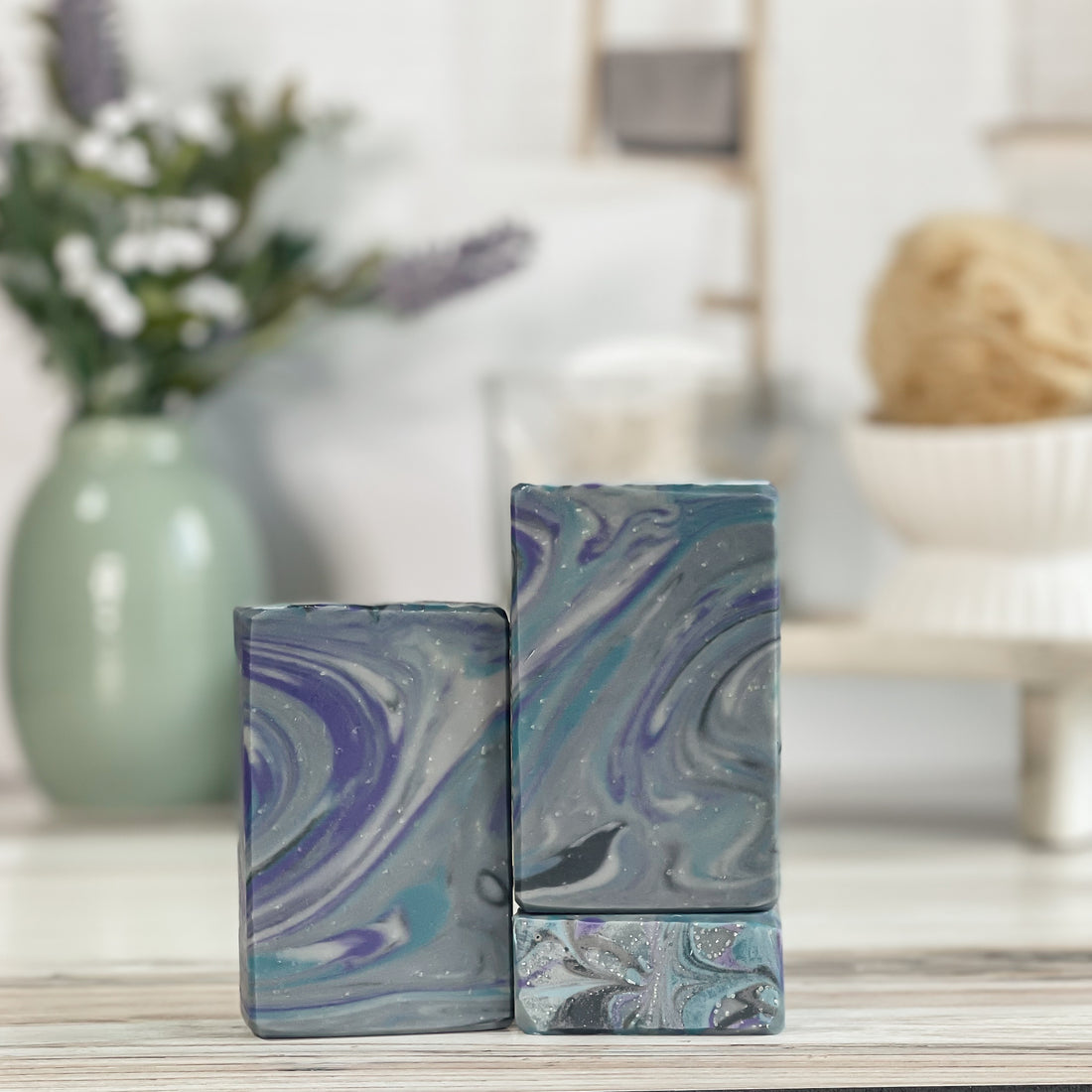 Marbled patterned perfectly manly soaps on a wooden surface with a blurred background