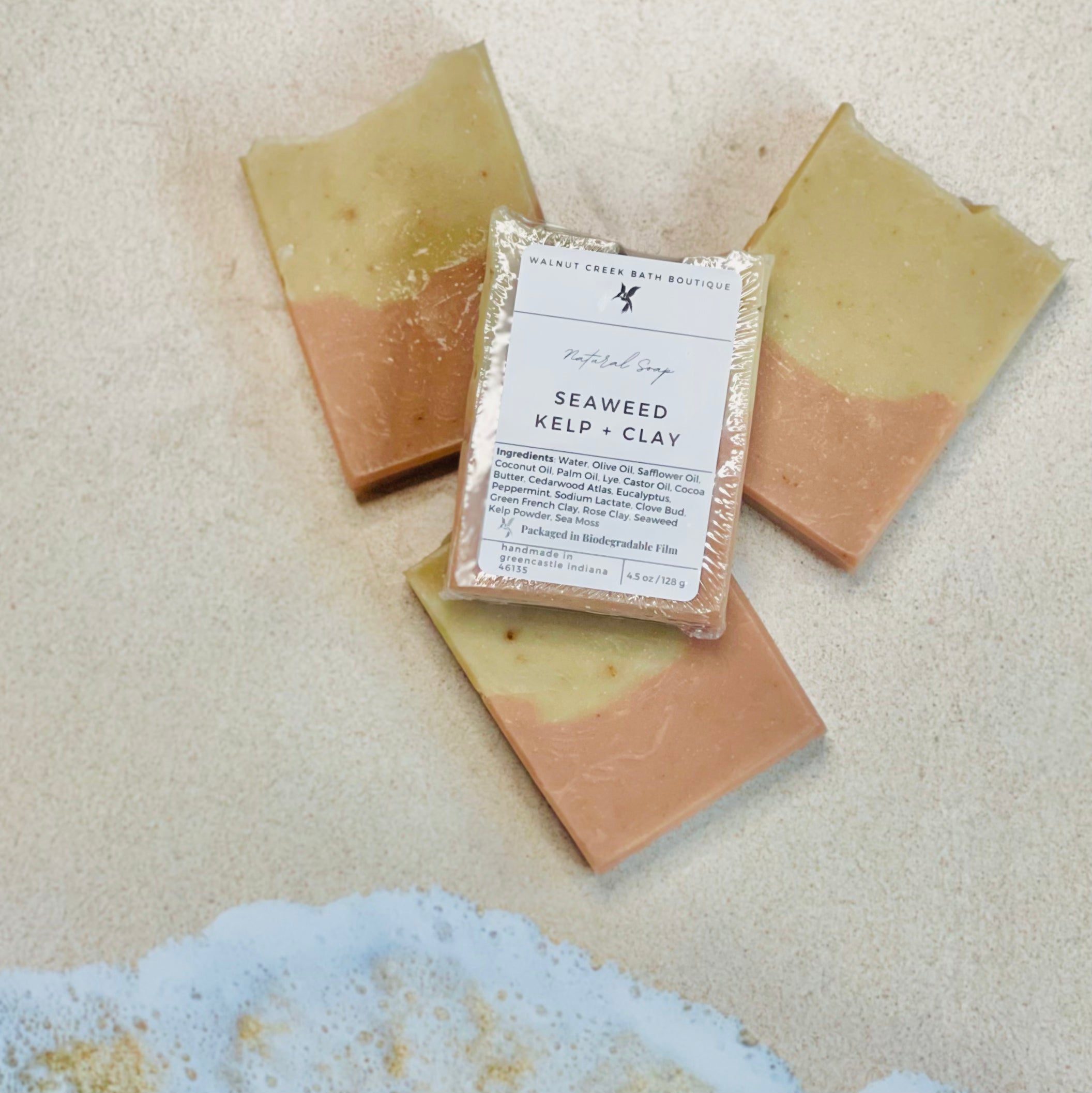 3 seaweed kelp and clay soaps are shown in a circular fan shape showing the tan and pink layers, there is a 4th soap laying across all the soaps to show the label.