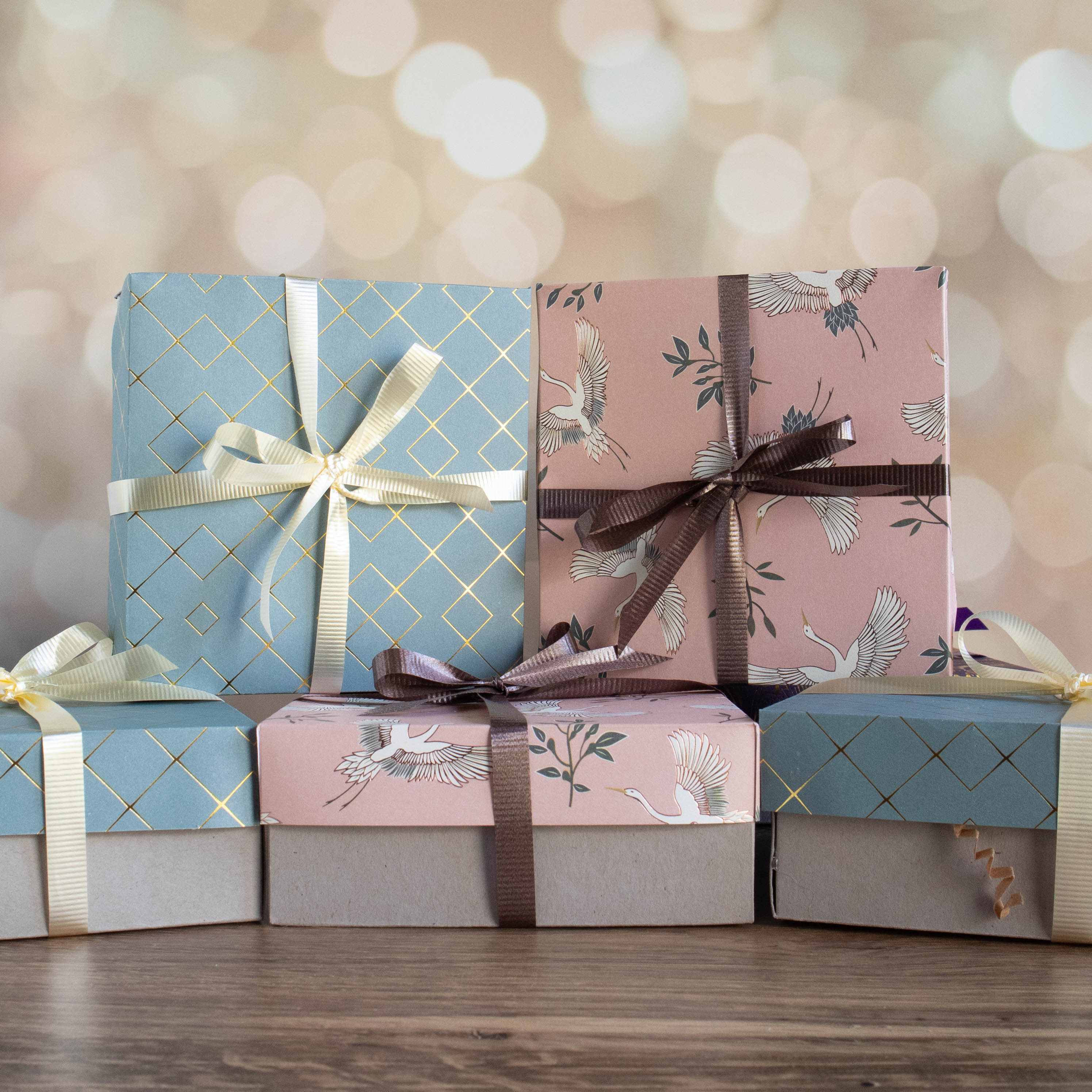 stack of soap of the month boxes with pretty patterned tops and matching ribbons 