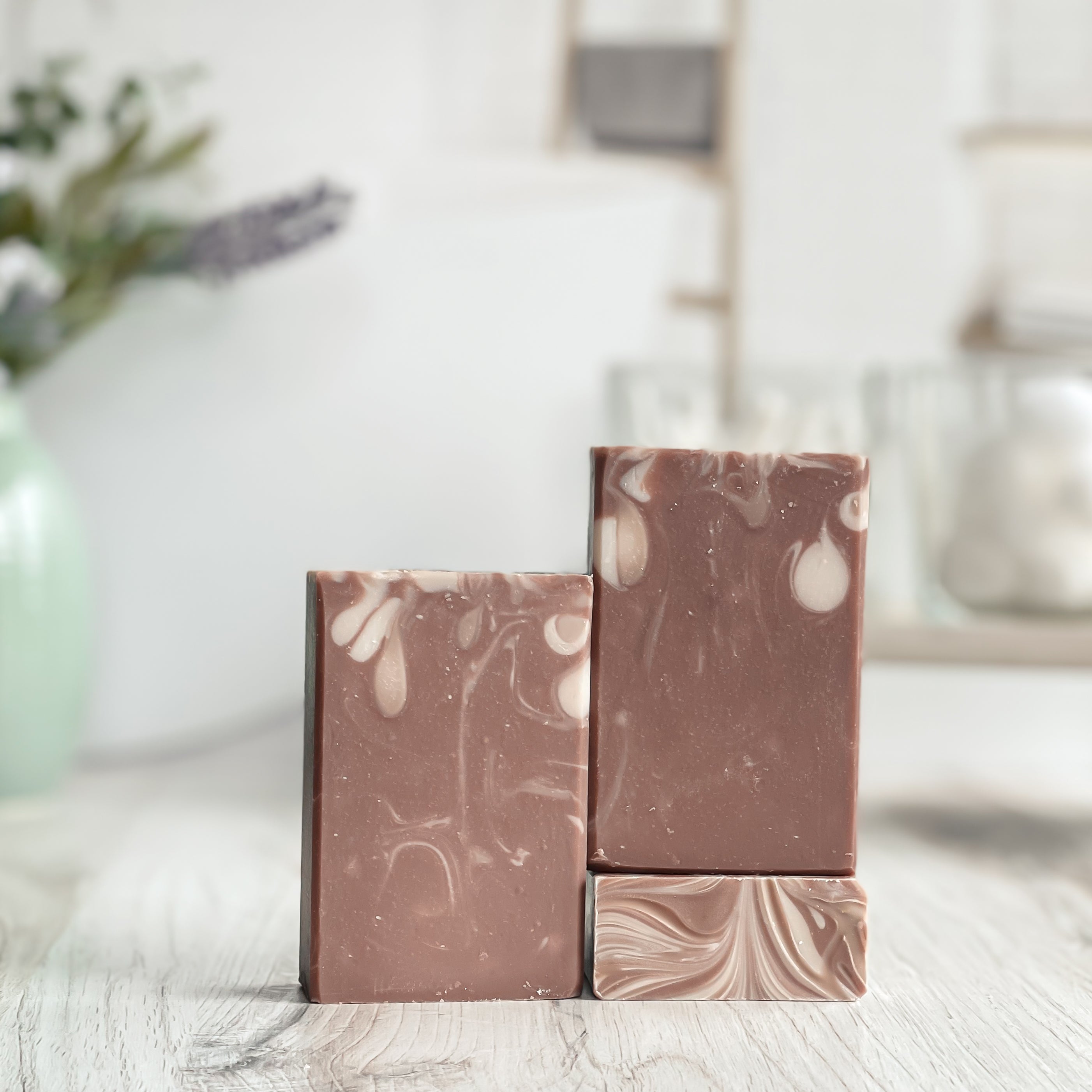 Marbled brown and beige soap bars on a light surface with a blurred background