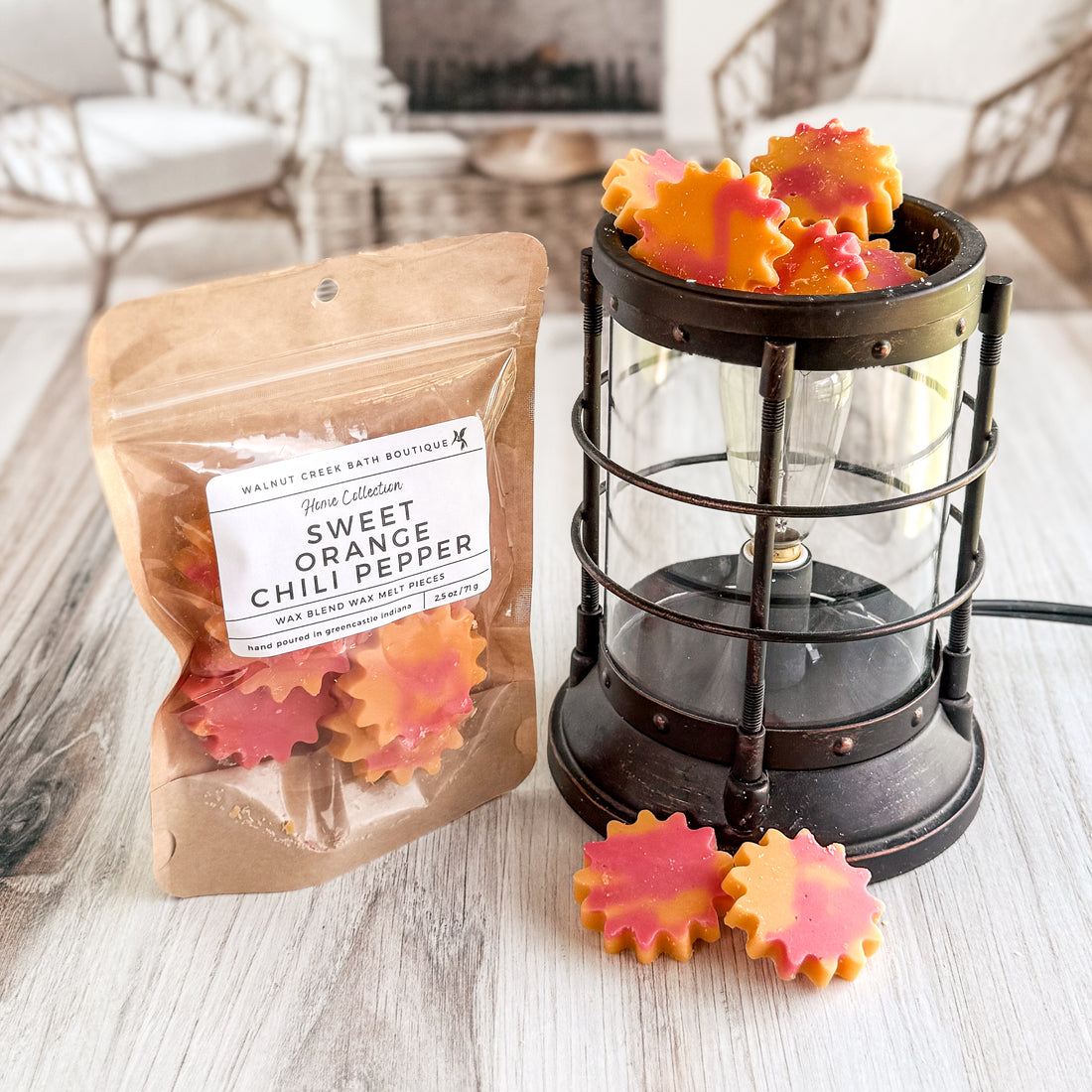Wax melts in packaging and a lantern on a wooden surface with a blurred indoor background