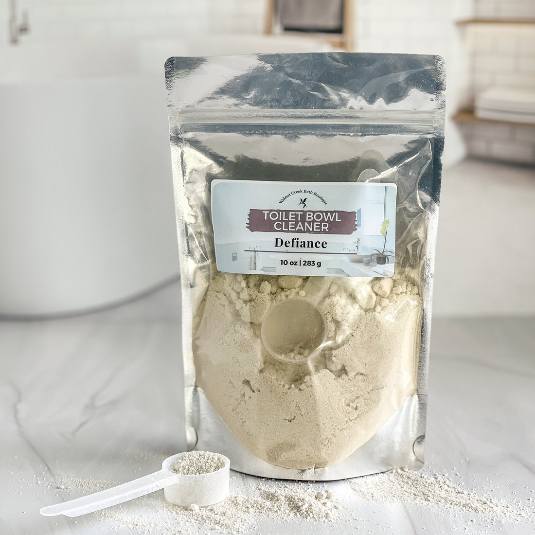 a bag of toilet bowl cleaning powder is shown with a scoop of powder next to it on the counter. there is some powder as well on the counter