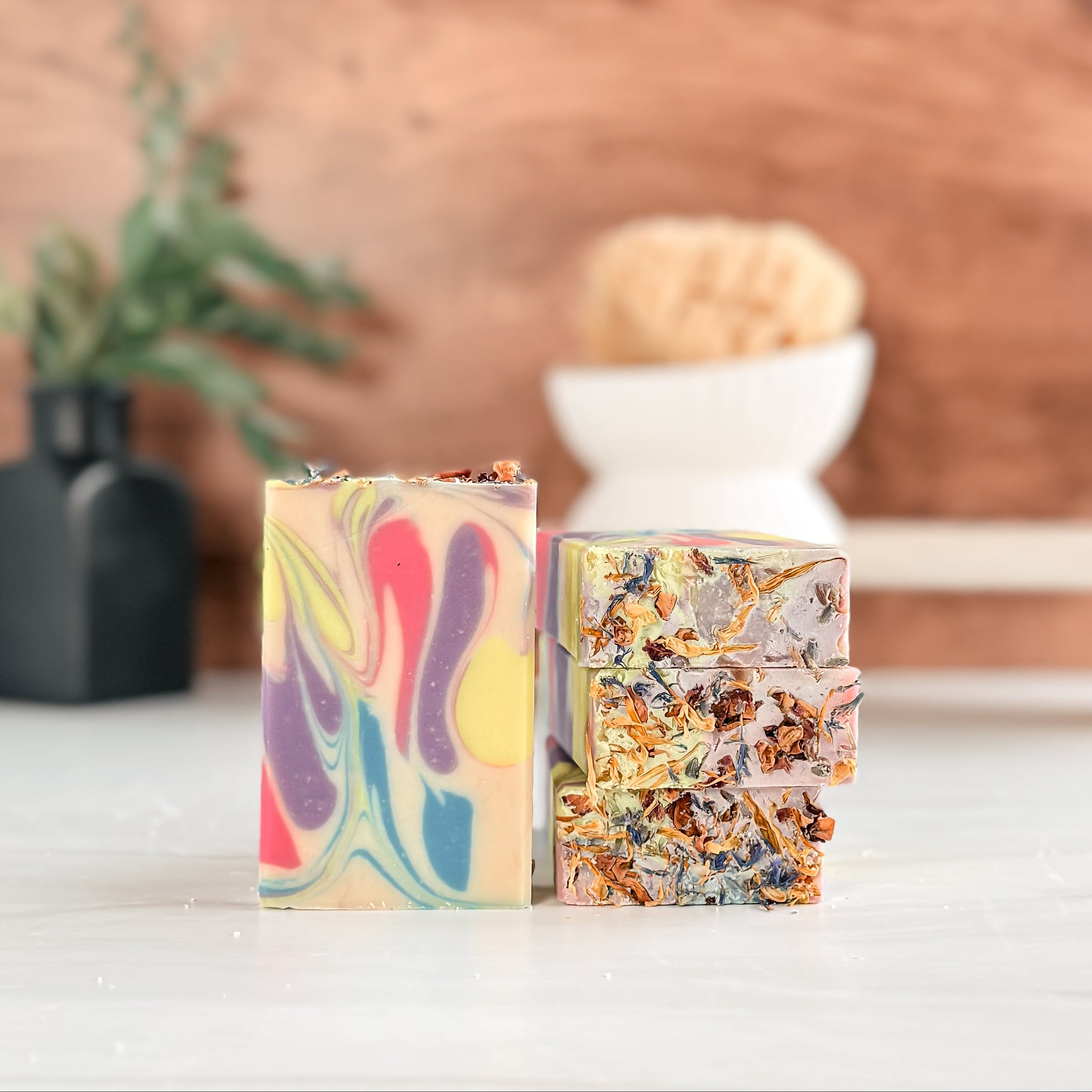 Two colorful soap bars on a wooden surface with a blurred background