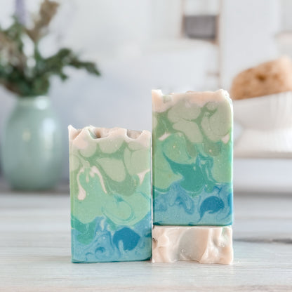 Two marbled soap bars on a wooden surface with a blurred background