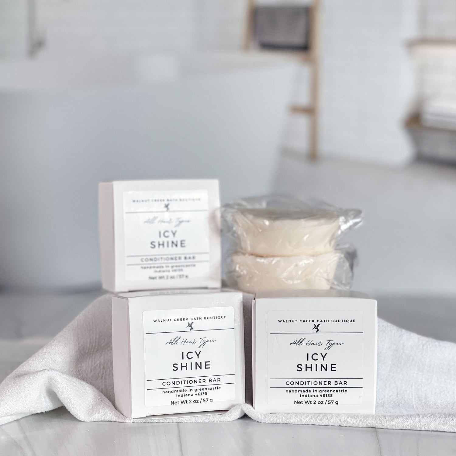 boxes of icy shine conditioner bars, along with an open bar to show creamy texture - some bars are lifted on a riser 
