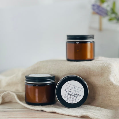 calendula oat face masks are shown, one laying on its side to show the simple label while the other two are standing upright. the mask is in amber glass jars with black lids. 