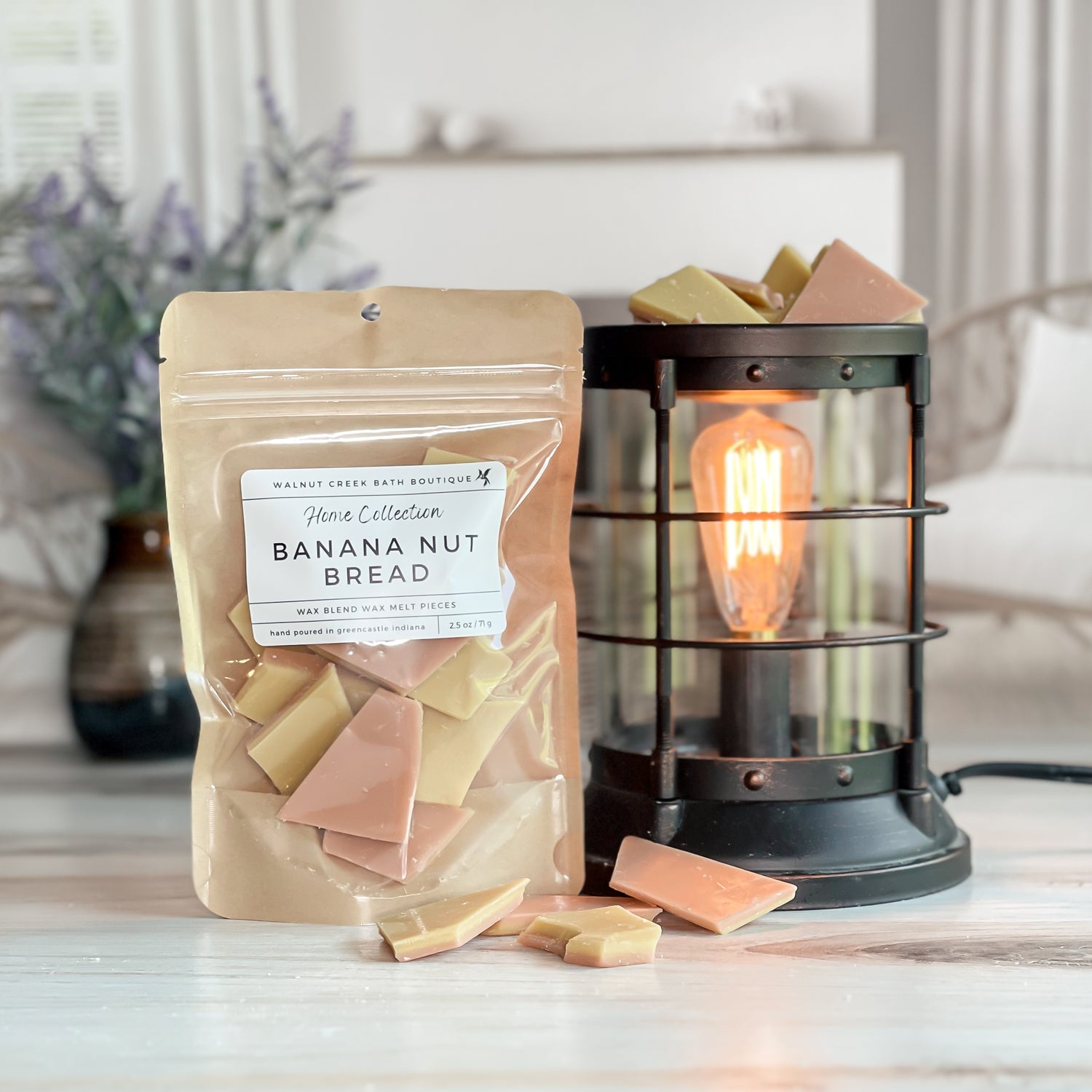 banana nut bread wax melt bag next to lit burner. there are wax melts on the table scattered about to shoe the pieces - these are tan and brown  two tone brittle type pieces