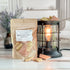 banana nut bread wax melt bag next to lit burner. there are wax melts on the table scattered about to shoe the pieces - these are tan and brown  two tone brittle type pieces