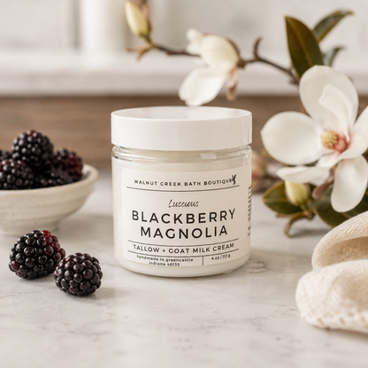 Jar of Blackberry Magnolia cream with blackberries and flowers on a marble surface