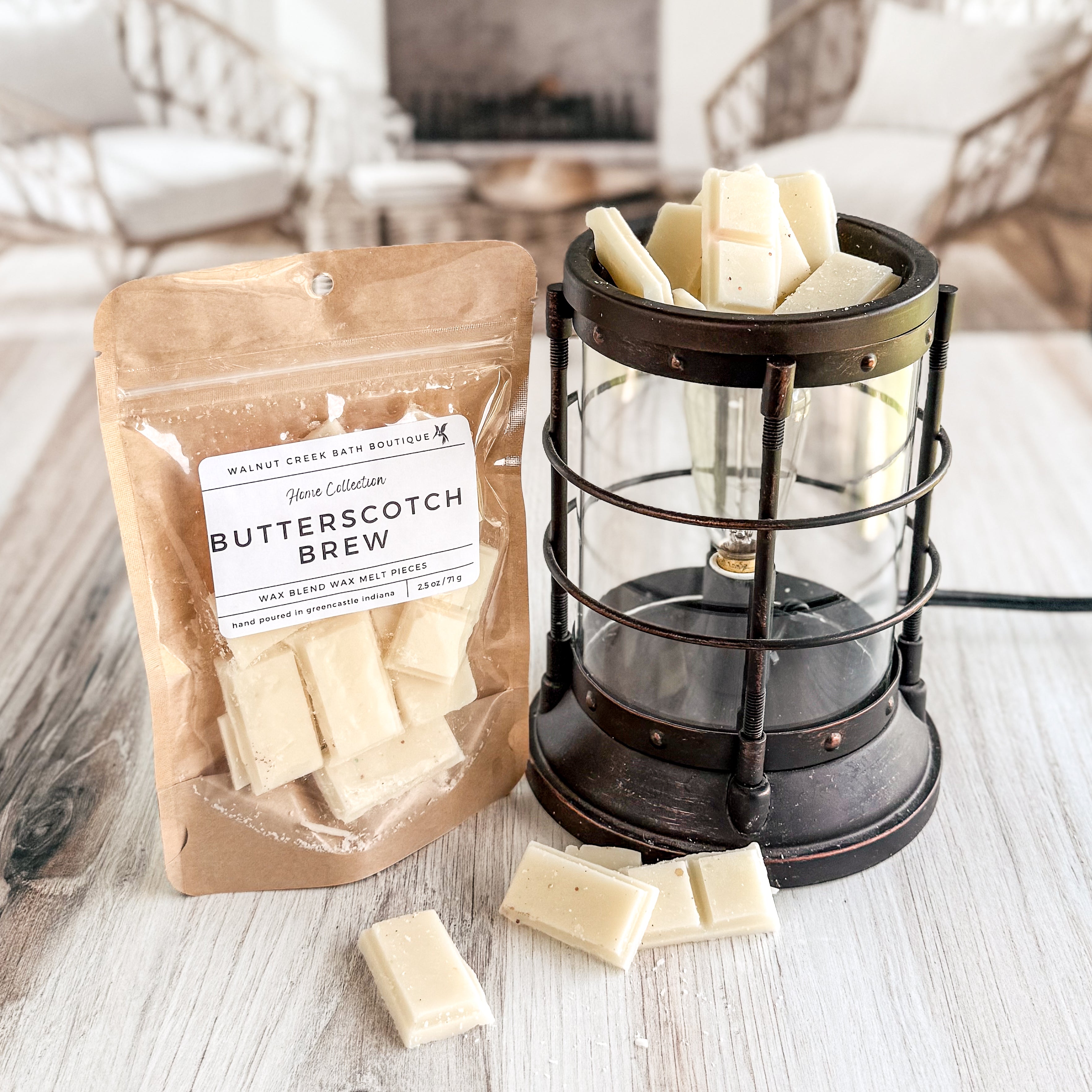 Butterscotch- coffee flavored wax melts in a packaging with a lantern and scattered wax melts on a wooden surface.