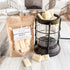 Butterscotch- coffee flavored wax melts in a packaging with a lantern and scattered wax melts on a wooden surface.