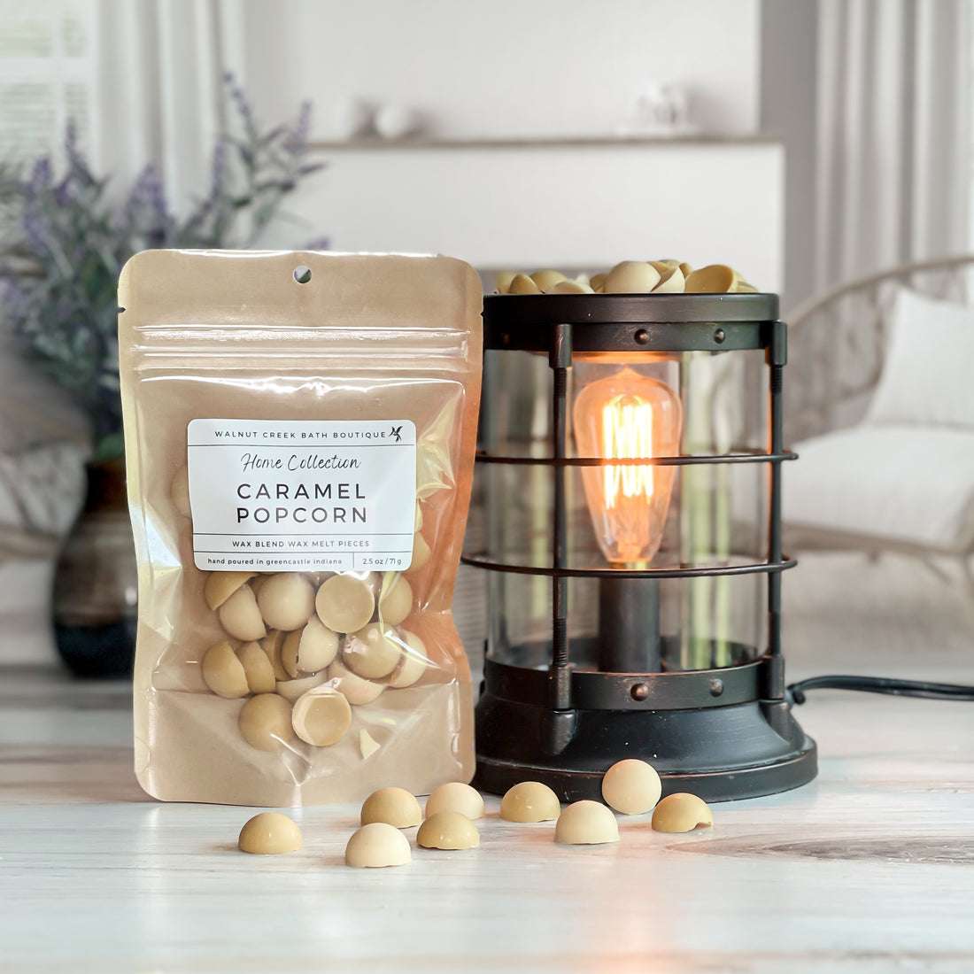 caramel popcorn wax melt bag next to lit burner. there are wax melts on the table scattered about to shoe the pieces - these are light tan and light brown dot pieces