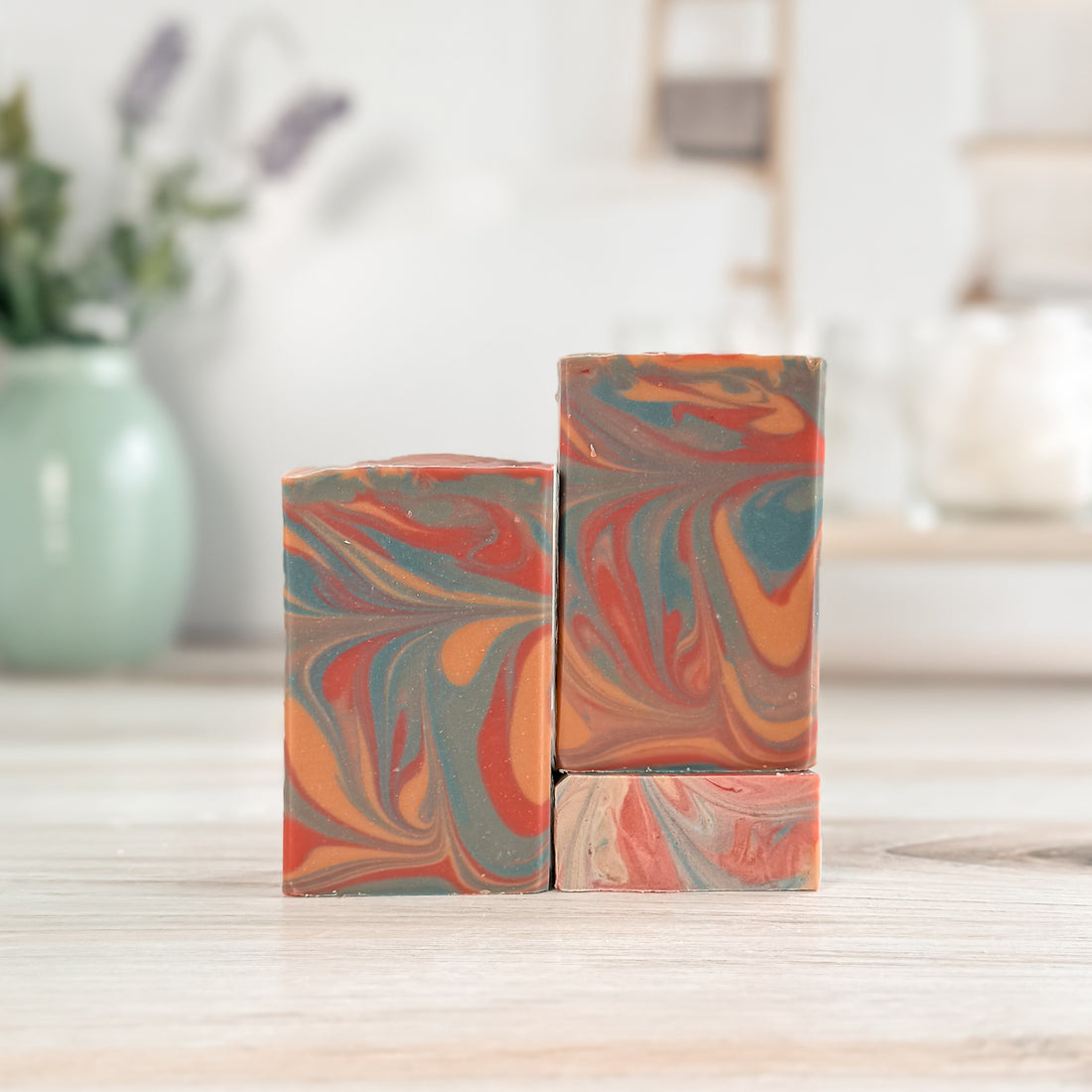 Marbled soap bars on a wooden surface with a blurred background