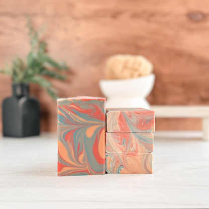 Marbled soap bars stacked on a wooden surface with a blurred background