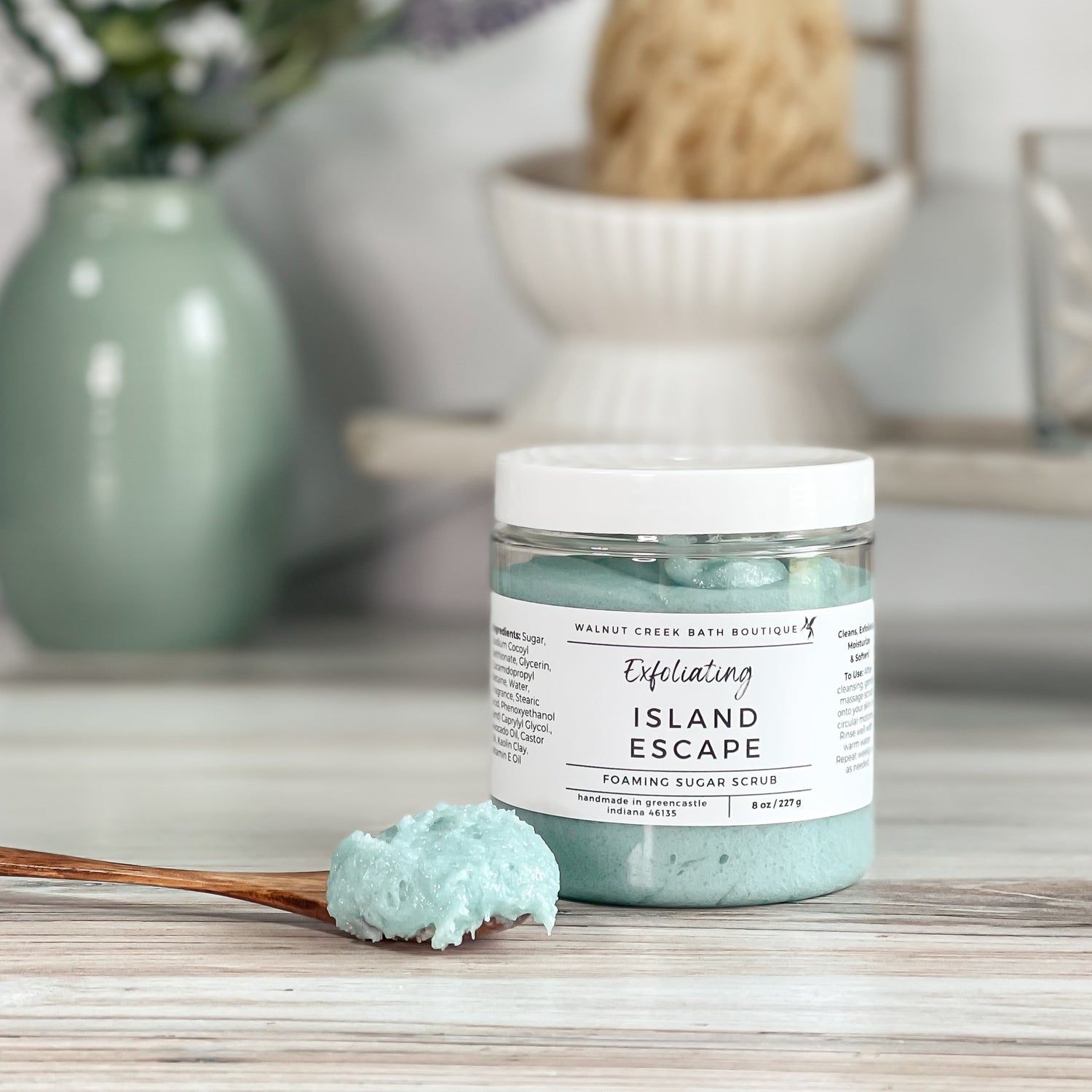 island escape foaming scrub with a spoonful of scrub sitting on table next to jar