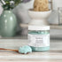 island escape foaming scrub with a spoonful of scrub sitting on table next to jar