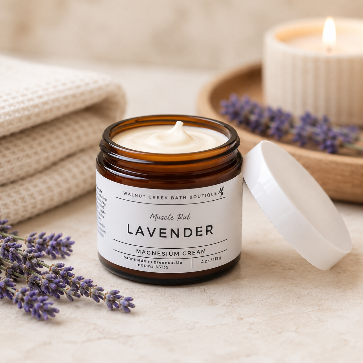 Lavender magnesium cream jar with lavender flowers and a candle in the background