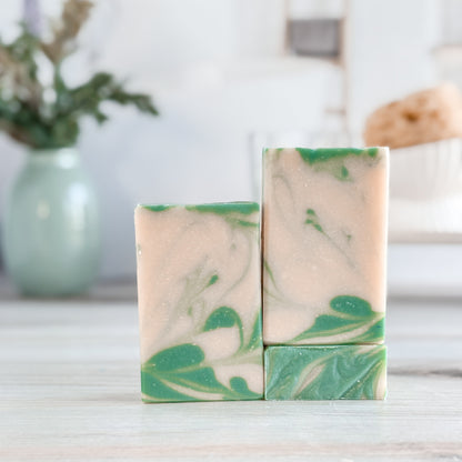 Three bars of soap with green and white marbled pattern on a blurred background