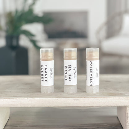 3 natural lip balms on a tray in a line to show simple labels