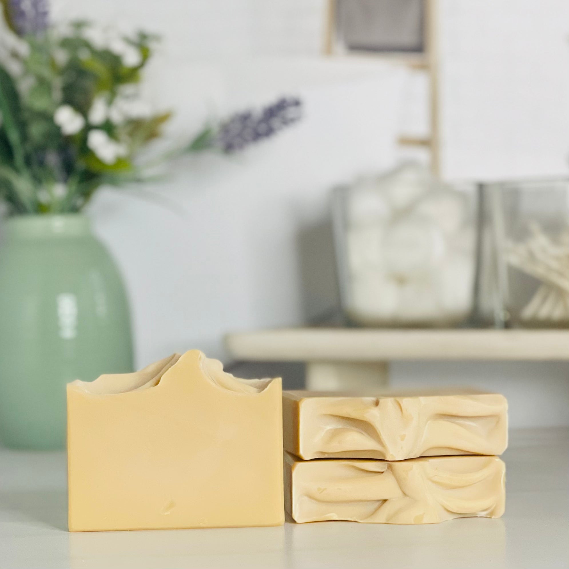 one patchouli sunrise soap is standing next to one laying flat to show the top and another standing on the flat one to show more of the soap colors