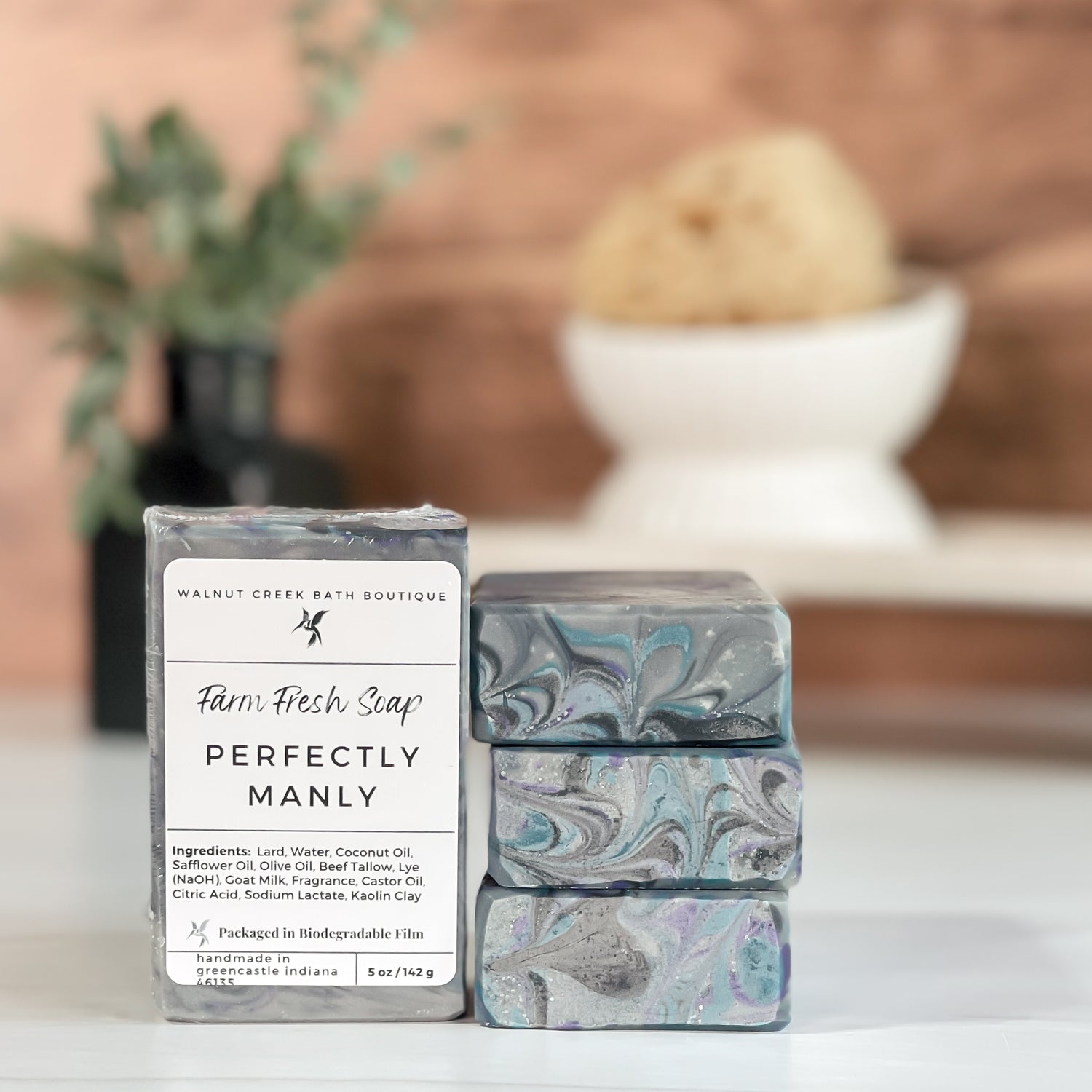 Three soap bars with marbled designs and a label on a surface with a blurred background