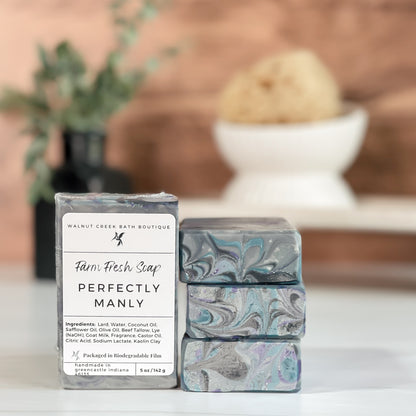 Three soap bars with marbled designs and a label on a surface with a blurred background