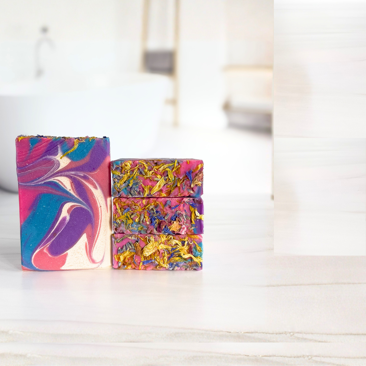 Two colorful soap bars on a white surface with a blurred background