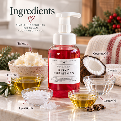 A bottle of Tallow Collection Risky Christmas Tallow Foaming Hand Soap stands on a marble surface with ingredient bowls and labels around it, including tallow, coconut oil, olive oil, glycerin, castor oil, and lye (KOH). The scene is styled with holiday greenery and a knitted blanket in the background.