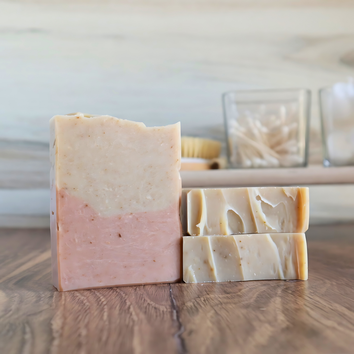 3 sea moss, seaweed kelp and clay soaps are shown. one standing facing you to show the two tones, pink on bottom and tan on top. two others are laying with the tops shown to show the textured tops of the soaps