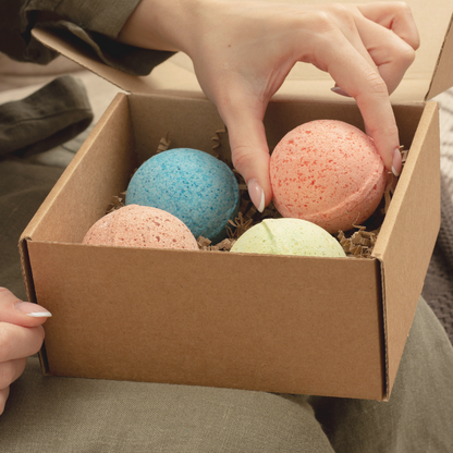 woman with a box of bath bombs on her lap as she is starting to pick one up