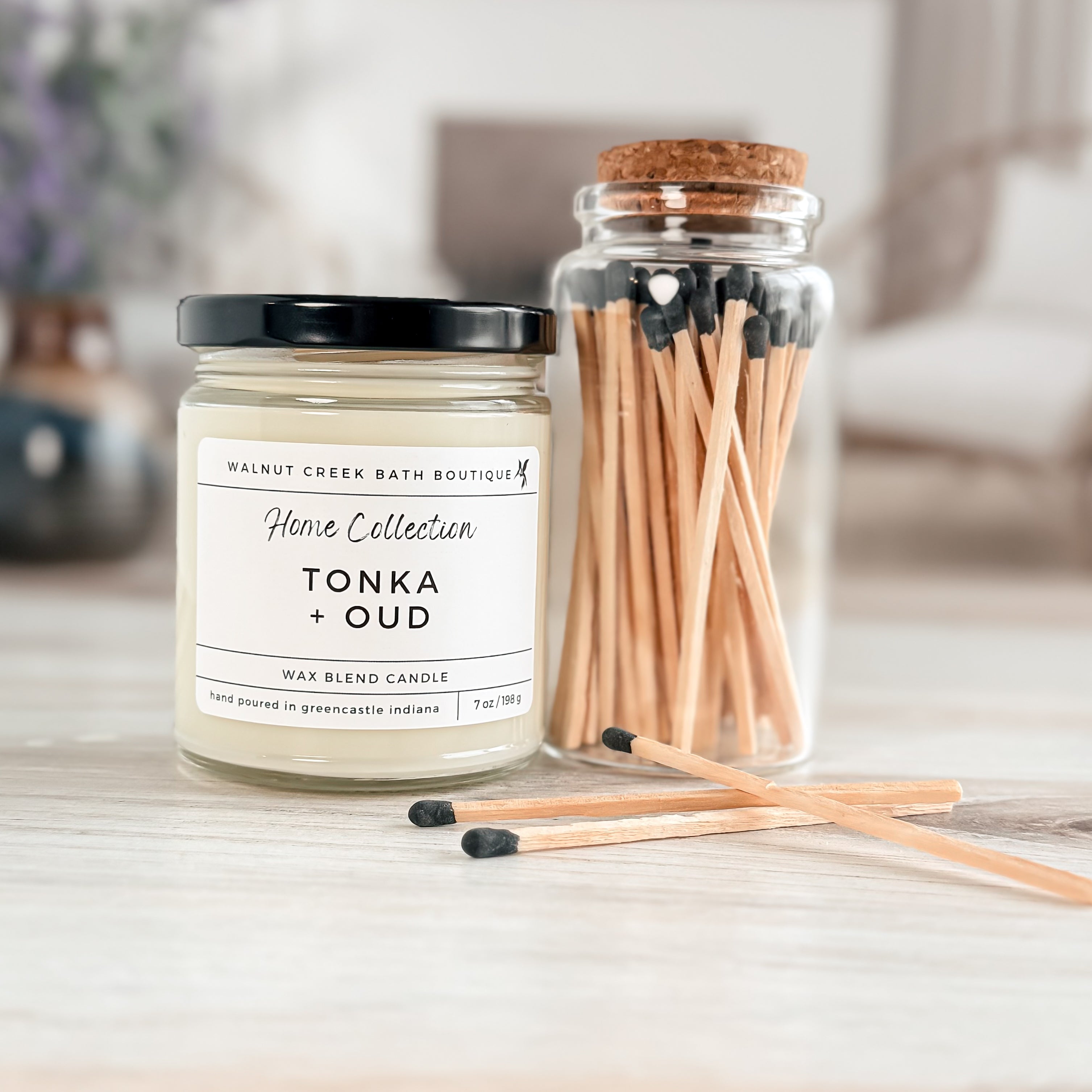 tonka and oud candle next to matchsticks