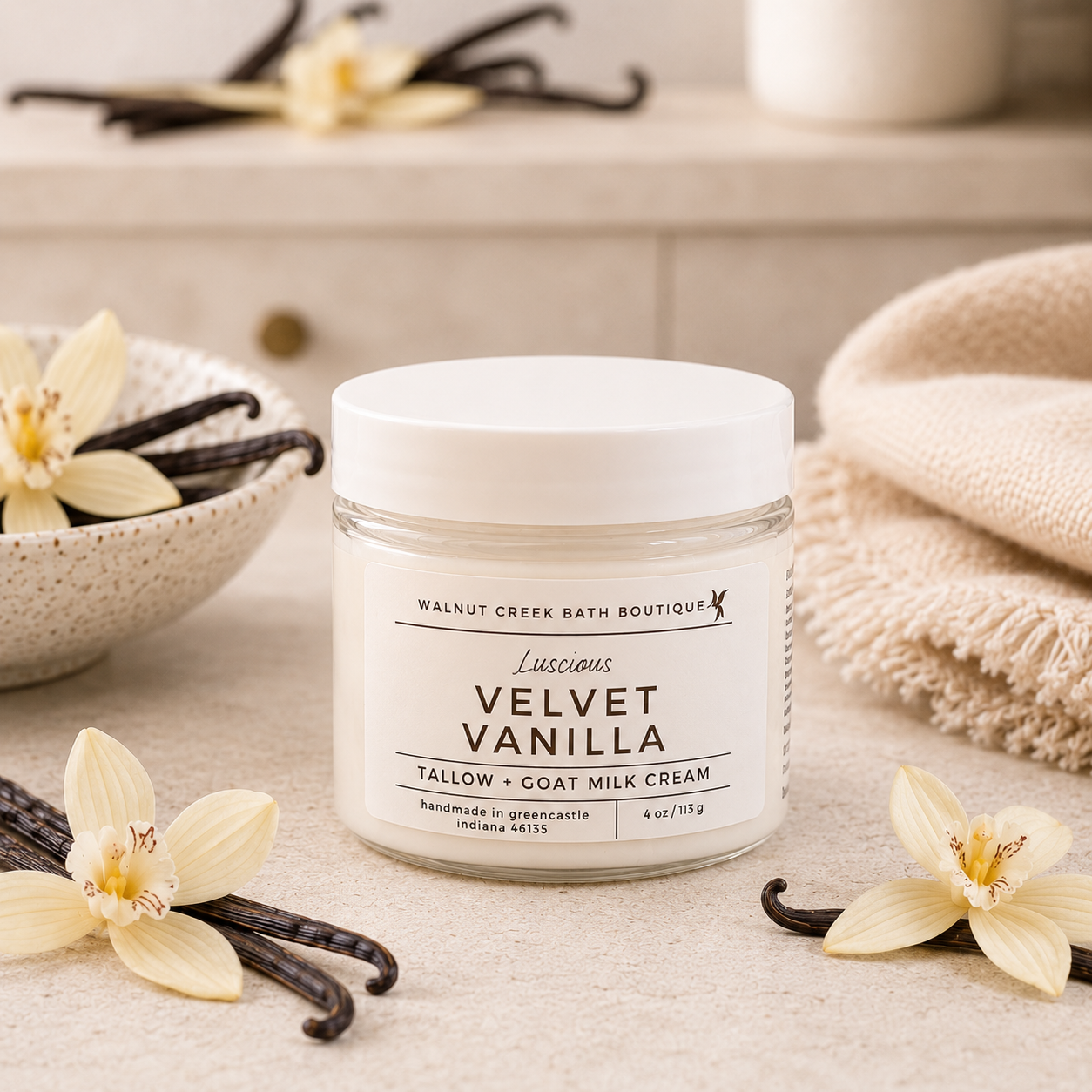 Jar of Velvet Vanilla cream with vanilla flowers and a towel in the background