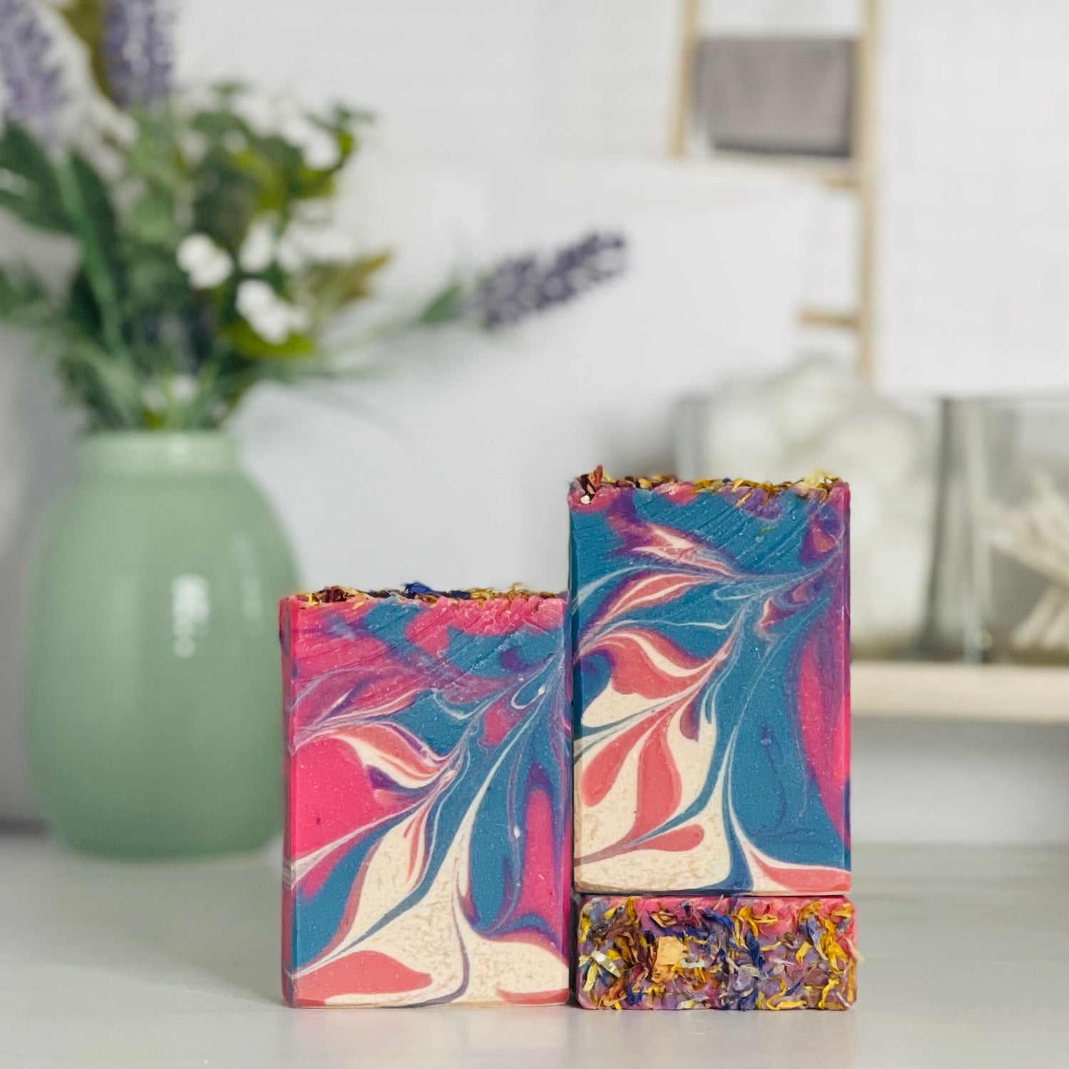one wildflower breeze soap is standing next to one laying flat to show the top and another standing on the flat one to show more of the soap colors