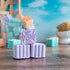 Soothing Lavender shower steamers stacked. One facing showing  a pretty scroll on top of the purple steamer. There is a mound of steamers in the background. There is a pretty blue sky in the background.